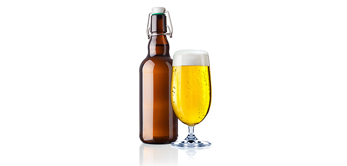 Ein volles Glas Bier steht neben einer Bierflasche