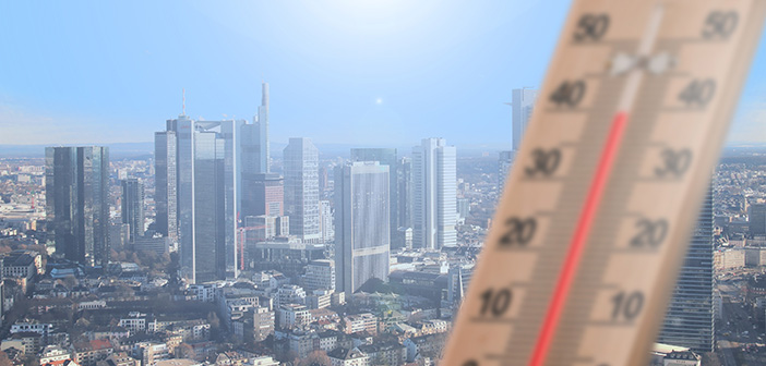 Bildmontage: ein Thermometer im Vordergrund zeigt knapp 40 Grad an, während im Hintergrund eine Großstadt mit Skyline aus der Vogelperspektive zu sehen ist.